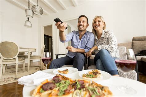 Leckere pizza direkt aus dem steinofen. Junge paare, die pizza essend genießen und zu hause ...