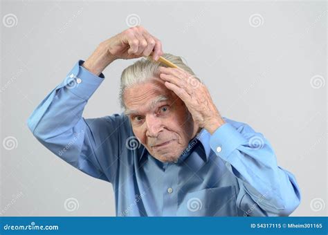 Homem Idoso Ativo Que Penteia Seu Cabelo Com Um Pente Imagem De Stock Imagem De Senior Pente