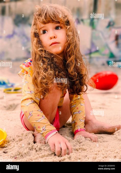 Portrait Of A Girl Sitting On The Beach Playing With Sand Rio De