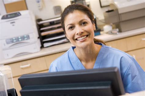 A Nurse Sitting At A Computer Stock Photo Image Of Scrubs Confidence