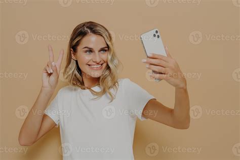 Cool Joyful Woman With Blonde Hair With Smartphone In Hand Making