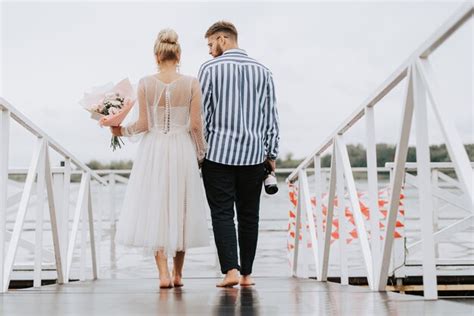Premium Photo The Just Married On The Wharf The Bride And Groom Walk Barefoot Along The Pier