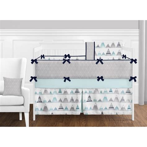 A Baby Crib Bedding Set With Blue And White Trees On The Side