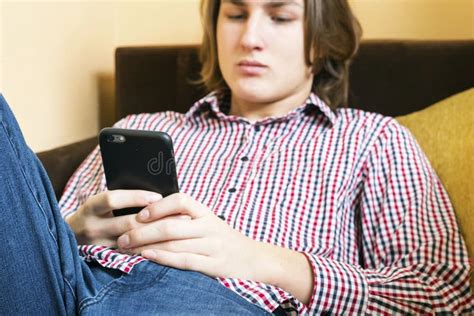 Молодой человек с телефоном в руках Стоковое Изображение изображение насчитывающей студент