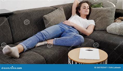 une jeune femme regarde la télévision allongée sur le canapé image stock image du regarder