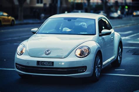 Close Up Of A Modern Volkswagen Beetle Driving Through The Streets Of