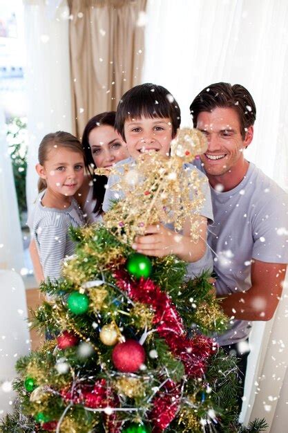 Imagen Compuesta De Familia Feliz Decorando Un Rbol De Navidad Con