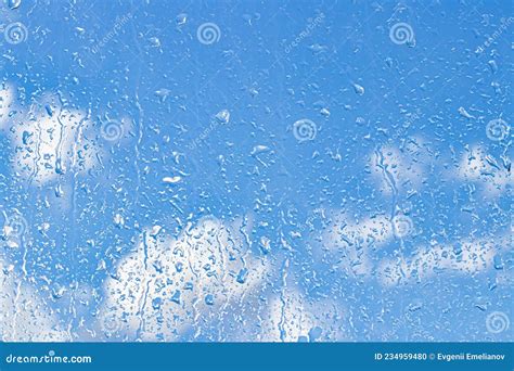 Rain Drops On Window Glasses Surface With Blue Sky And Clouds