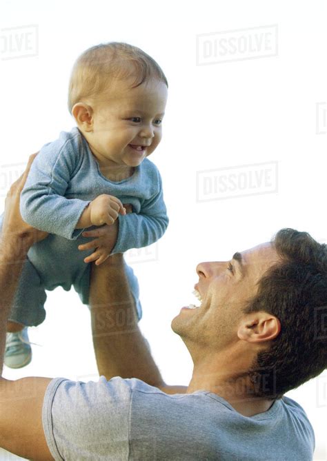 Man Holding Up Baby In Air Stock Photo Dissolve