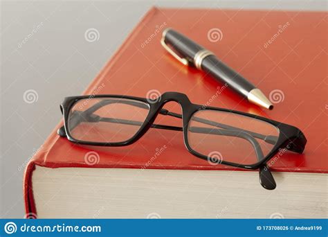 Close Up On A Red Book Cover Eyeglasses And A Pen With Copy Space For