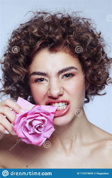 Beautiful Girl With Curly Hair And Clean Makeup Biting Pink Rose In Her Hand Stock Image Image
