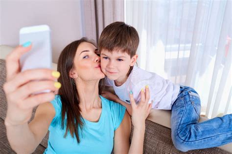 Madre Joven Y Su Hijo Que Toman Un Selfie En El Sofá Fami Feliz Foto De Archivo Imagen De Amor
