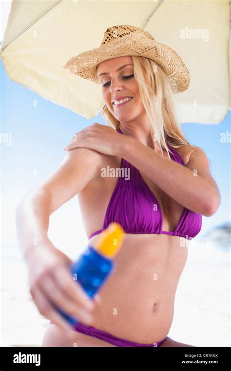 Woman Applying Sunscreen On Beach Stock Photo Alamy