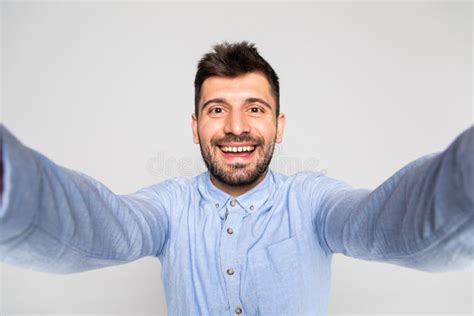 Close Up Portrait Of A Cheerful Bearded Man Taking Selfie Over Gray