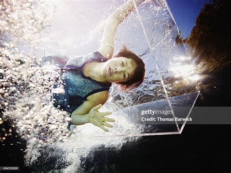 Underwater View Of Woman Trapped In Glass Box High Res Stock Photo