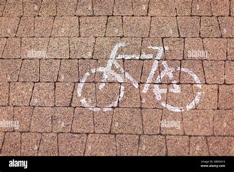 Road sign bicycle path painted in white on a cobblestone road. Concept