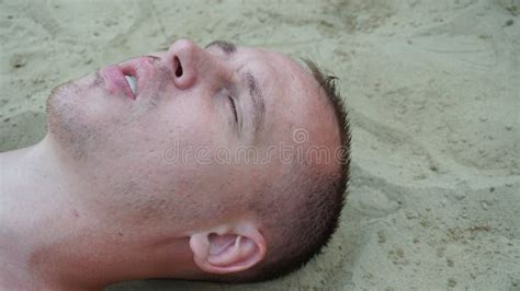 A Young Man Lies On The Sand On The Beach Stock Photo Image Of