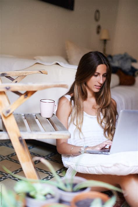 Pretty Girl Sitting In Bedroom And Typing On Laptop By Guille Faingold