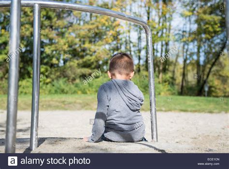 Small Lonely Boy Sitting Alone In Playground Stock Photo Alamy