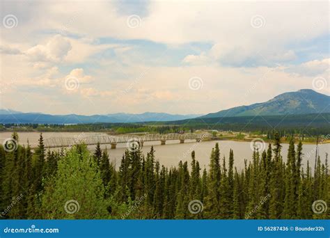 A Bridge With A Dramatic Sky In The Yukon Territories Stock Photo