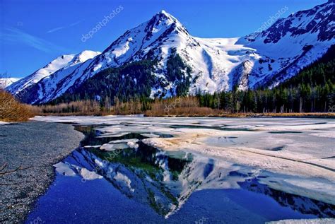 Partially Frozen Lake With Mountain Range Reflected In The Great