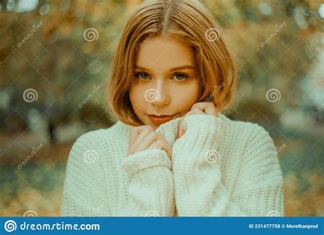 Photo Portrait Of A Girl In A White Sweater The Blonde Holds The Neck