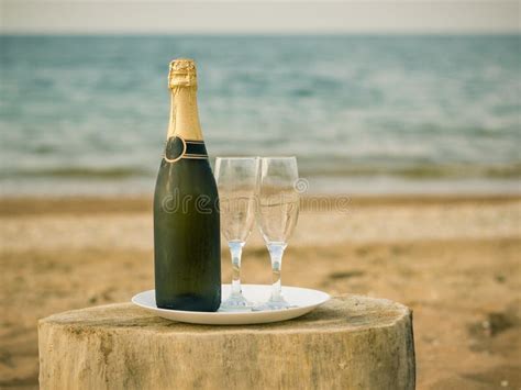 A Bottle Of Cold Champagne Glasses And Strawberries On A Sandy Beach