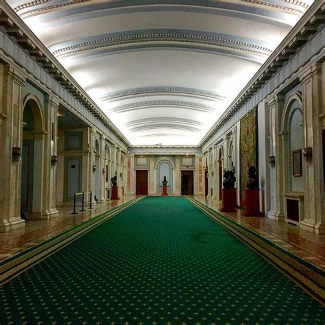 An Ornate Hallway With Green Carpet And Arches