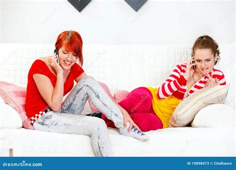 Freundinnen Die Auf Sofa Sitzen Und Auf Mobiles Sprechen Stockbild Bild Von Kissen Freizeit