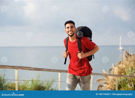 Happy Young Man Walking With Backpack By The Sea Stock Photo Image Of