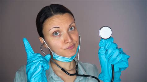 Retrato De Un Médico O Una Enfermera Con Un Estetoscopio En Uniforme Azul Máscara Protectora Y