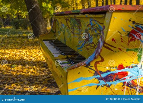 Painted Colors Of The Piano In An Autumn Park Maple Leaf Lies On The