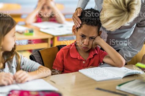 Female Teacher Consoling Crying Black Student In The Classroom Stock