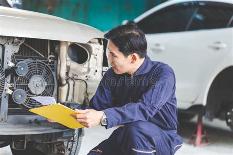 Technician With A Checklist Checking Modern Car At Garage Auto