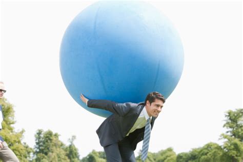 Businessman Holding Large Ball On Back Stock Photo Download Image Now