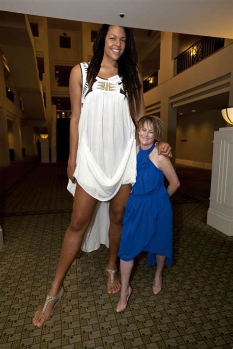 Two Women Standing Next To Each Other In A Room