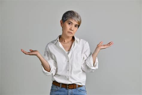 image of confused puzzled upset middle aged asian woman standing isolated over white background