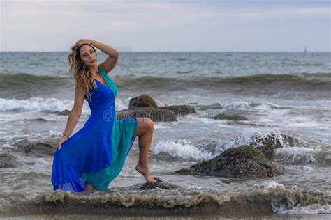 lovely brunette latin model poses outdoors on a beach at sunset stock