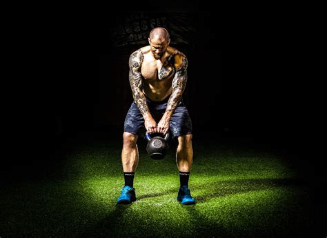 Athletic Man Exercising With Kettlebells