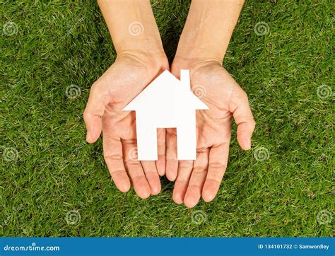 Hands Holding A House In Conceptual Image Of Plans For Housing