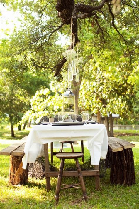 An Outdoor Table Set For Two Under A Tree