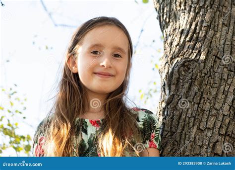 Cute Five Year Old Girl Sitting On A Tree In The Summer In Nature Stock