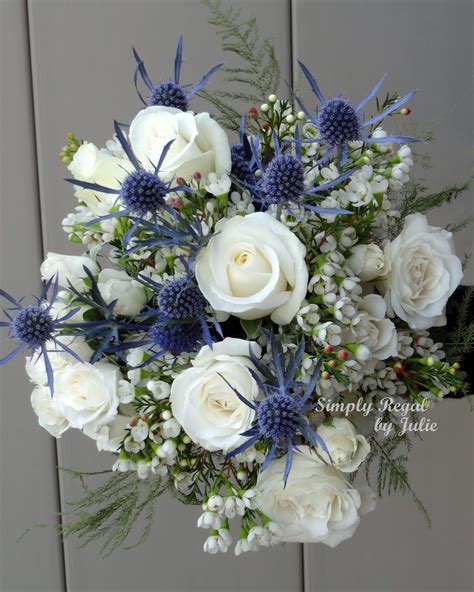 bouquet with white roses blue thistle and white waxflower simply regal by julie small wedding