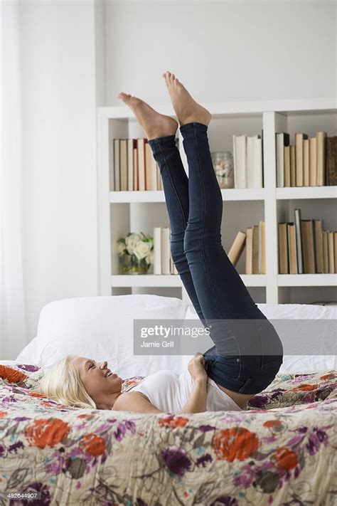 Woman Putting On Skinny Jeans On Bed Jersey City New Jersey Usa Photo