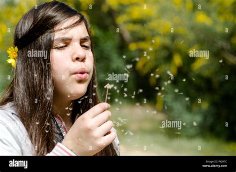 Beautiful Young Caucasian Teenage Girl Blowing Dandelion Flower Stock