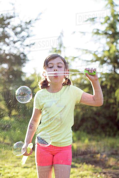 Young Girl Blowing Bubbles Outdoors Stock Photo Dissolve