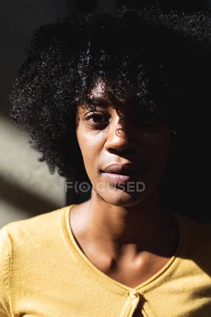 Portrait Of African American Woman Looking At Camera In High Contrast Interior Digital