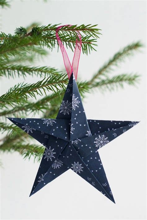 An Origami Star Hanging From A Christmas Tree