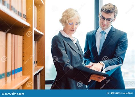 Senior And Junior Lawyer In Law Firm Discussing Strategy In A Case