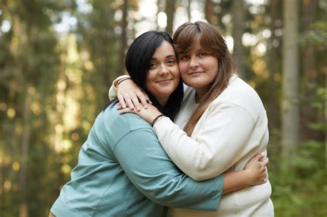 Premium Photo Portrait Of Two Young Lesbians Embracing Each Other And Smiling At Camera While